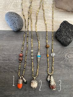 Unique and powerful beaded ethnic necklaces. Made with black wax string, small round and rectangular brass beads and each has a unique and different Tibetan pendant with white metal embossed details and different stones. Some are made with Carnelian stone, Tibetan Conch shell, Coral, Turquoise, black Pearl etc etc. Each necklace also has a different unique bead taking part of the necklace, either glass bead, stone bead etc. They don't have a clasp, all of them you wear them over the head. A perf Bronze Beaded Necklace With Polished Beads As Gift, Spiritual Brass Jewelry With Polished Beads, Spiritual Silver Beaded Necklaces For Festivals, Beaded Brass Amulet Jewelry, Brass Beaded Necklaces With Gemstone Beads, Brass Necklaces With Round Natural Stone Beads, Brass Round Beads Necklace With Natural Stones, Brass Beaded Necklace With Gemstone Beads, Bronze Adjustable Beaded Necklaces, Traditional Style