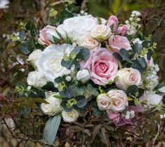 a bouquet of white and pink flowers with greenery