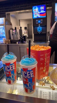 two buckets of ice cream and popcorn on a counter at a fast food restaurant