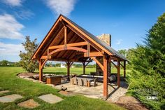 an outdoor pavilion with picnic table and grill