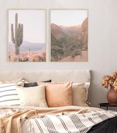 a bed with two pictures hanging above it and pillows on the bottom, along with a vase filled with flowers