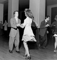 an old photo of people dancing on the dance floor