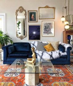 a living room with blue couches and pictures on the wall above them, along with a glass coffee table