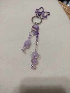 a keychain with beads and charms on it sitting on a white tablecloth