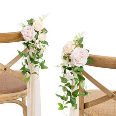 two wooden chairs with flowers and greenery attached to the back of them, against a white background