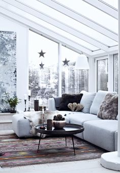 a living room filled with lots of furniture next to large windows and stars on the wall