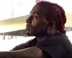 a man with red dreadlocks sitting in a car and looking out the window