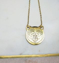 "This gold laser cut grizzly bear necklace is a perfect momma bear necklace. Great gift for any zoo animals lover. You can wear this wildlife jewellery on its own or layering with other necklaces.  ✽ Size of the pendant: 2.4 cm x 2.4 cm =1\" x 1\" All my jewelry is lead and nickle free. ✽ ENVIRONMENTAL FRIENDLY PACKAGE I was always feeling bad for creating more waste on this planet so I try to be environmental friendly everywhere where possible. All my wrapping material is biodegradable and recyclable :) My jewelry comes on A6 designed paper in a cellophane bag. All packed in very thick cardboard envelopes to protect my goodies, made from recycled paper. I also offer extra gift wrapping, which you can see and choose at checkout. Oh and don't forget to visit my social media to see work in p Bear Design Pendant Jewelry For Gifts, Bear Design Pendant Jewelry Gift, Bear Design Pendant Jewelry As Gift, Wolf Design Round Jewelry Gift, Round Wolf Design Jewelry Gift, Gold Animal Design Necklace For Gift, Gold Necklace With Animal Design For Gift, Endangered Animals Project, Mama Bear Necklace