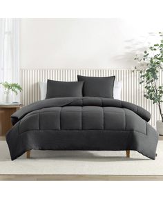 the comforter is made up with dark gray linens and has two pillows on each side