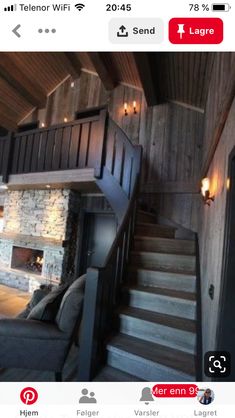 a living room filled with furniture next to a fire place under a wooden ceiling and stairs