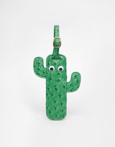 a green cactus shaped luggage tag with eyes