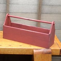 a wooden box sitting on top of a table next to a brick wall and door