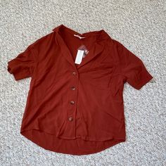 Burnt Orange Button Up Short Sleeve Top. 4 Brown Colored Buttons With A Front Left Breast Pocket. Bought This From A Boutique But Can’t Remember Which One. Really Cute To Tuck Into Jeans With Booties Orange Collared Top With Button Closure, Orange Short Sleeve Top With Buttons, Orange Collared Top With Buttons, Brown Tops With Button Closure For Day Out, Brown Buttoned Tops For Day Out, Brown Tops With Buttons For Day Out, Casual Orange Blouse With Button Closure, Orange V-neck Top With Buttons, Orange Short Sleeve Blouse With Buttons