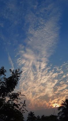 the sun is setting behind some clouds in the sky