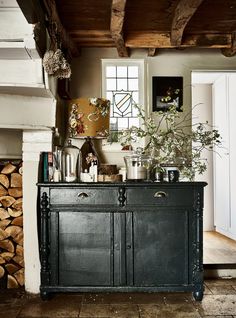 an old dresser is in the middle of a room with wood stacked on top of it