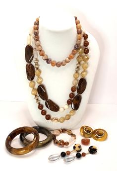 Vintage 70's to 90's Lucite Shades of Beige Brown Root Beer Coffee and Cream Necklace Earrings Bracelet Ring A curated collection of mix and match large earrings , chunky necklaces, beaded bracelet and bangle bracelets and one Lucite ring for good measure! 2 necklaces 2 bangle bracelets 2 pairs of earrings 1 beaded bracelet 1 ring These are vintage items, they have been cleaned, inspected and found to be in very good condition. Comes in a gift box ideal for gift giving and storage. Luxury Vintage Brown Necklace, Luxury Vintage Brown Necklaces, Collectible Brown Jewelry With Natural Stones, Retro Adjustable Brown Jewelry, Retro Brown Adjustable Jewelry, Brown Natural Stones Jewelry For Collectors, Brown Natural Stones Round Jewelry, Brown Adjustable Costume Jewelry, Adjustable Brown Costume Jewelry