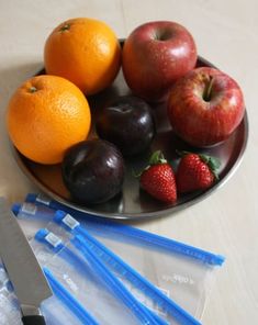 some fruit is sitting on a plate with blue strawberries and oranges next to it