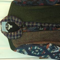 three different colored sweaters are stacked on top of each other, one is green and the other is multicolored