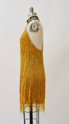 "80s Bob Mackie Super Chic Vintage Gold beaded and sequin dress features: * Silk chiffon body fully embellished with gold glass beads and stunning strands of beaded fringe * Beaded/sequined geometric pattern around neckline * Stunning t-strap back zip closure * Scalloped hemline * Fully lined with back zip closure * Great Vintage condition By Bob Mackie Boutique Size 6, fits like a small 100% silk Length from High point shoulder 33\" Bust 33\" Waist 30\" Hip 39\" All measurements are given in fu Gatsby Style Beaded Flapper Dress For Party, Glamorous Sequined Flapper Dress For Costume Party, Flapper Style Sleeveless Embellished Sequin Dress, Sleeveless Embellished Flapper Sequin Dress, Beaded Flapper Party Dress, Flapper Style Sequin Dress For Summer Party, Beaded Flapper Evening Dresses, Flapper Party Dress With Beaded Details, Summer Flapper Style Sequin Party Dress