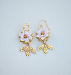 Featuring Statement earrings in white Magnolia with gold center with gold tone brass leaves. Note : if you prefer different color as seen in the last picture, please drop a note. Otherwise it will be shipped as white-gold as pictured. Details: Hand-Sculpted magnolia .Size approx : 18-19mm. Flowers glued gold plated over brass filigree as pictured. Brass Leaves in white gold tone. French hook Ear-wires. Made to order : 3-5 business days for single item plus shipping time. However if you need them Delicate Nickel-free White Earrings, Delicate White Nickel-free Earrings, White Brass Pierced Earrings, White Brass Earrings For Gift, White Brass Earrings As Gift, White Brass Earrings For Pierced Ears, White Flower-shaped Pierced Earrings, White Brass Earrings With Ear Wire, White Brass Dangle Earrings