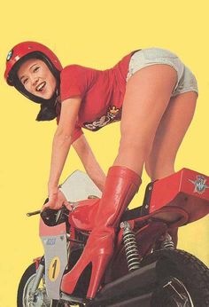 a woman in red riding on the back of a motorbike with her legs spread out