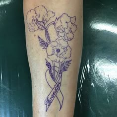 a tattoo on the leg of a woman with flowers and a ribbon around her ankles