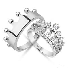 two silver rings with crowns on each one and diamonds in the middle, set against a white background