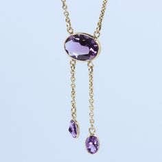 "Vintage Minimalist Lavalier Necklace in 14k Gold with Bezel Set, Oval Cut, Amethysts. This necklace bears a makers hallmark with \"rings and the letter A\", there is also a 14k Purity mark, no origin mark. Necklace measures 15.75\" Total Drop of Lavalier Pendant 1.75\" 1X - 13.6x9.8x5.85 mm Large Amethyst Oval Gem 2X - 7x4.5x3.75 mm Small Amethyst Oval Gems Total weight of necklace 0.179 Oz (78.1 g) This item is vintage. It has been cherished, worn, and preserved by possibly many over the decad Elegant Oval Pendant Gemstone Drop Necklace, Elegant Oval Lariat Necklace As Gift, Elegant Oval Lariat Necklace For Gift, Modern Briolette Necklace For Gift, Classic Drop Necklace With Delicate Chain For Formal Events, Classic Drop Necklace With Delicate Chain For Formal Occasions, Modern Briolette Necklace For Gifts, Minimalist 14k Gold Drop Necklace For Formal Occasions, Modern Yellow Gold Drop Necklace Gift