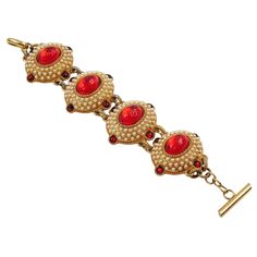 This lovely French Designer Chantal Thomass Paris jeweled link bracelet features gilded-metal carved and domed elements, all paved and ornate with half pearl-like and ruby red cabochons. An impressive ruby-red textured resin cabochon embellishes each link in its center. Toggle fastening clasp with the signature engraved: "Chantal Thomass." Each link is signed at the back with the brand logo. The bracelet is in good condition, with minor gilt fading at the back, but it does not significantly affect the overall appearance. Measurements: 8.25 in long (21 cm) - 1.69 in wide (4.2 cm) - fit an average 5 to 7 in wrist. Feel free to double-check the measurements and ask any questions you have before making your purchase. This item is a final sale. We will not accept returns for an unfit size. Italian Necklace, Glamorous Jewelry, Chantal Thomass, Platinum Bracelet, Gold Link Bracelet, French Jewelry, Antique Bracelets, Bracelet Pearl, White Gold Set