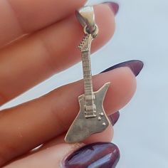 Product Description: This handmade 925 Sterling Silver Electric Guitar Pendant is a truly remarkable piece, meticulously crafted to resemble a real electric guitar. Its accuracy in details makes it an ideal gift for guitar players and music enthusiasts alike, perfect for occasions such as birthdays, anniversaries, or just to show appreciation to a fellow musician. Highlights: - Handmade item - Made with 925 Sterling Silver - Immaculately detailed - Dispatches from a small business in Greece  Ben Silver Rock Jewelry For Concerts, Silver Rock Style Jewelry For Concerts, Sterling Silver Jewelry For Concerts, Silver Rock Style Jewelry, Silver Rock Style Necklace Gift, Silver Rock Style Necklace As Gift, Silver Rock Style Necklace For Gift, Guitar Pendant, Guitar Players