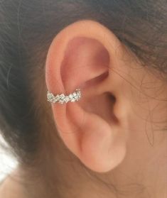 a woman's ear is shown with three small diamonds on the middle part of it