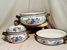 three white dishes with floral designs on them