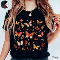 Autumnal Butterflies Unisex Cottagecore Tee Shirt | Butterfly Shirt | Boho Tee | Cottagecore Clothing  ✔️ Soft, light and comfortable unisex short sleeve tee ✔️ 100% Airlume combed and ringspun cotton (fiber content may vary for different colours*) ✔️ Light fabric (4.2 oz/yd² (142 g/m ✔️ Retail fit 📏 Runs true to size ✔️ Dual side seams for structural support of the garment help hold its shape longer ✔️ Ribbed knit elastic collars to bolster shaping, twill taped shoulders to prevent stretching Black Cotton T-shirt With Butterfly Print, Casual Black Tops With Butterfly Print, Casual Black Top With Butterfly Print, Short Sleeve Butterfly Print Graphic Tee, Short Sleeve Graphic Tee With Butterfly Print, Multicolor Short Sleeve T-shirt With Butterfly Print, Multicolor Crew Neck Top With Butterfly Print, Butterfly Print Short Sleeve Graphic Tee, Cotton Multicolor Tops With Butterfly Print