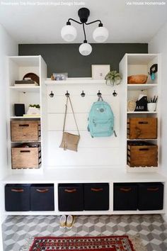 a room with some shelves and baskets on the wall next to a rug in front of it