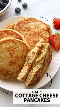 three pancakes on a plate with blueberries and strawberries next to it, labeled fluffy cottage cheese pancakes