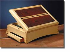 a wooden box with two drawers on the bottom and one drawer open to show what is inside