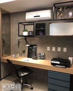 a desk with a computer and printer on it in a home office space that is well lit