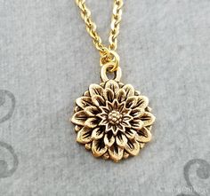 "This listing is for a zinnia flower charm necklace. You'll be able to choose your chain length and style at checkout by using the \"Chain Length/Style\" drop-down menu. Keyrings, bangle bracelets, ball chains, and black/brown leather and suede cord are also available. **Please see the second photo for scale! If you're on the mobile site, just swipe to the side. :) **Please note that this is gold-tone and not actually made from real gold. ITEM CARE: Avoid contact with water, for best results. - Delicate Flower Pendant Charm Necklace, Nickel Free, Delicate Nickel-free Flower Pendant Charm Necklace, Dainty Flower-shaped Nickel-free Necklace, Metal Flower Charm Necklaces, Metal Necklace With Flower Charm For Gift, Dainty Metal Necklace With Flower Charm, Brass Pendant Necklace With Flower Charm, Flower Charm Necklace For Bridesmaid Gift, Gold Nickel-free Flower Pendant Necklace