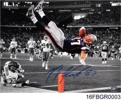 an autographed photograph of a football player diving into the air to catch a ball