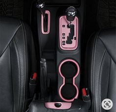 the interior of a car with pink and black trims, steering wheel controls and center console