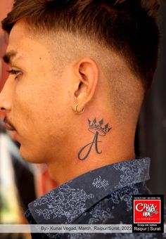 a man with a crown tattoo on his neck and behind his ear, looking to the side