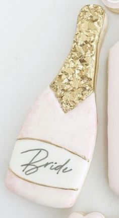 a pink bottle with gold glitter on it next to a pair of scissors and comb