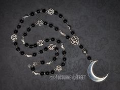 A beautiful gothic rosary, handmade by Nocturne Street. Featuring a large silver moon suspended from a pentagram. The chain is made from black glass beads, dotted with silver moons and pentagrams. The charms used in this pieces are made from Tibetan Silver and the necklace fastens with a silver plated lobster clasp, although it can fit over the head. The rosary chain measures about 28 inches when unclasped and laid flat. The moon measures 35x45mm. This moon rosary will be packaged in a pretty organza gift bag and would make a lovely gift. It would look perfect with a trad goth or whimsigoth outfit. Visit my shop to see the complete collection of gothic earrings. Only pay one lot of postage, the rest of your order ships free! ✨ Gothic Silver Jewelry With Round Beads, Silver Gothic Jewelry With Round Beads, Gothic Silver Necklaces With Round Beads, Gothic Silver Necklace With Round Beads, Silver Gothic Necklaces With Round Beads, Silver Round Beads Jewelry For Halloween, Halloween Silver Jewelry With Round Beads, Silver Jewelry With Round Beads For Halloween, Silver Jewelry With 108 Beads For Festivals