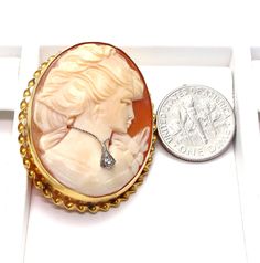 "14k Yellow Gold Cameo Diamond Brooch pendant Beautiful detailed carving on her hair and flowers on her dress Clasp and pendant hoop in good working condition Stamped: \"14k\" inside of the rim Measures approx. 1 1/2\" long X 1 1/4\" wide or 3.9 cm X 3 cm Outside rim measures approx. 2 mm wide - Twisted rope Diamond is approx: .02 ct Total weight: 8.1 g 041315-4070 FEEL FREE TO MESSAGE ME IF YOU HAVE ANY QUESTIONS OR WISH TO SEE MORE PICTURES * Back to Shop Watch and Wares? https://www.etsy.com/ Elegant Carved Brooches For Gifts, Elegant Carved Gold Brooches, Oval Brooches For Formal Occasions, Carved Yellow Gold Brooches For Wedding, Exquisite Brooches For Wedding, Carved Brooches For Formal Occasions, Exquisite Collectible Jewelry Brooch, Exquisite Collectible Brooch Jewelry, Yellow Gold Intaglio Jewelry