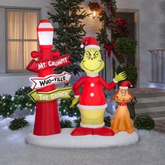 a christmas display in front of a house decorated for the holiday season with street signs