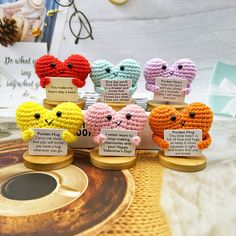 small crocheted hearts with price tags on them sitting on a table next to other items