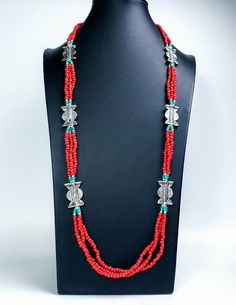 Add color and pizzazz to any outfit with this beautiful hand crafted Tibetan coral color multi strand bead necklace with silver tone amulets. The faux turquoise accents makes the amulets pop! A simple but very striking necklace! Perfect for a beach vacation with a carefree white dress or in the city to dress up jeans. Makes a beautiful gift! Twist the necklace for a totally different look! Excellent quality and craftsmanship. - 3 strands of irregular beads - bright red/orange color - silvertone Traditional Multi-strand Gemstone Bead Jewelry, Red Spiritual Long Necklace, Spiritual Long Red Necklace, Traditional Handmade Double Strand Beaded Necklaces, Traditional Double Strand Beads For Gift, Traditional Handmade Double Strand Beaded Necklace, Traditional Double Strand Beaded Jewelry, Traditional Multi-strand Jewelry With Large Beads, Silver Multi-strand Bohemian Beads