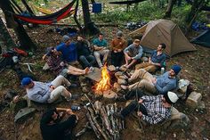 a group of people sitting around a campfire