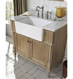 a white sink sitting on top of a wooden cabinet