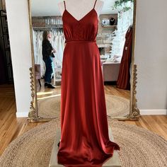 a red dress on display in front of a mirror